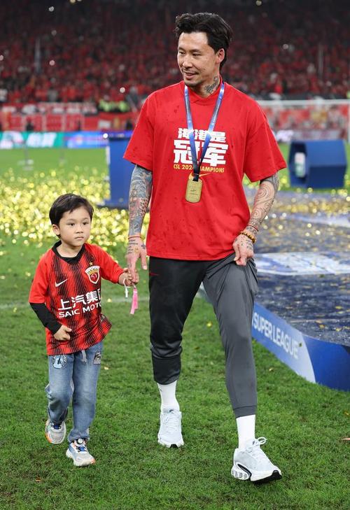 上海海港举行夺冠庆功仪式，武磊、张琳芃等球员为徐根宝佩戴奖牌